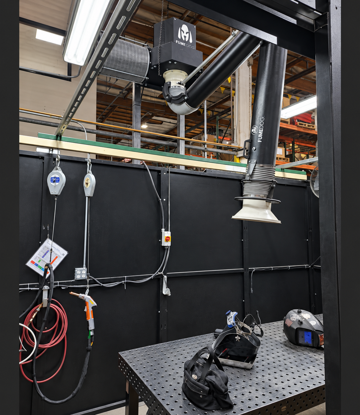 Customized Acorn Engineering LightSAFE interior with overhead fume extraction, suspended welding tools and a perforated welding table.